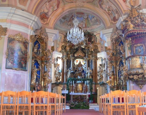 Glavni oltar, posvečen Mariji, je delo več avtorjev, levo je slika Marijin sprejem v nebes