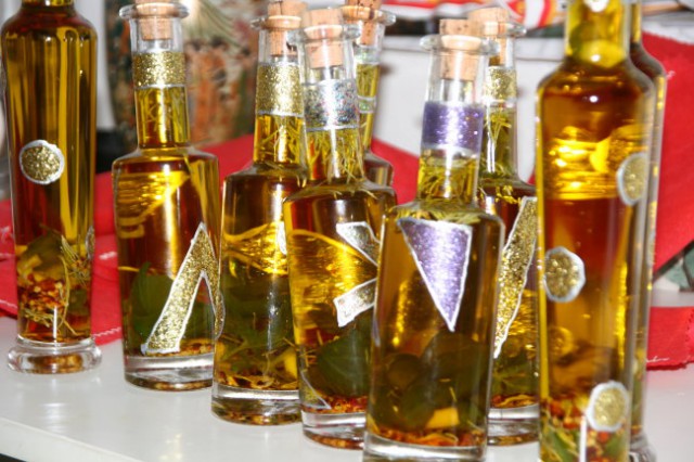 Steklenicke z olivnim oljem in zelisci. 