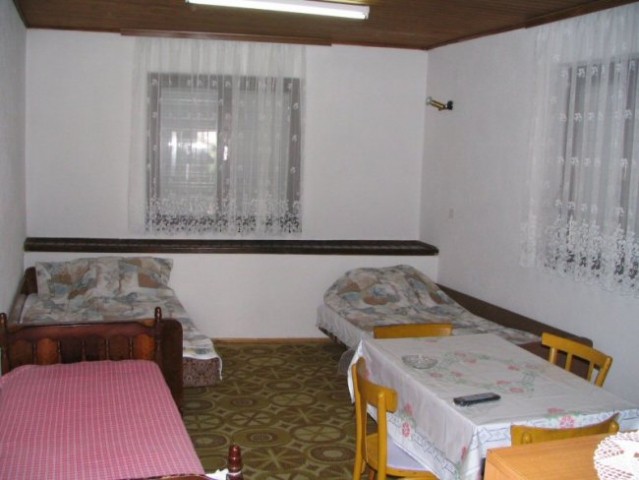 APARTMAN - Pogled iz hodnika na sobo, kjer so tri postelje.